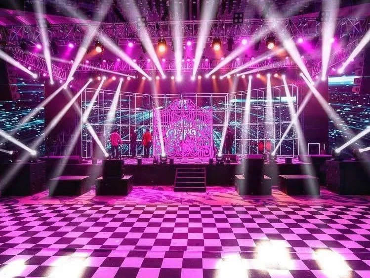 Celebration dance floor and stage illuminated with vibrant pink and purple lighting
